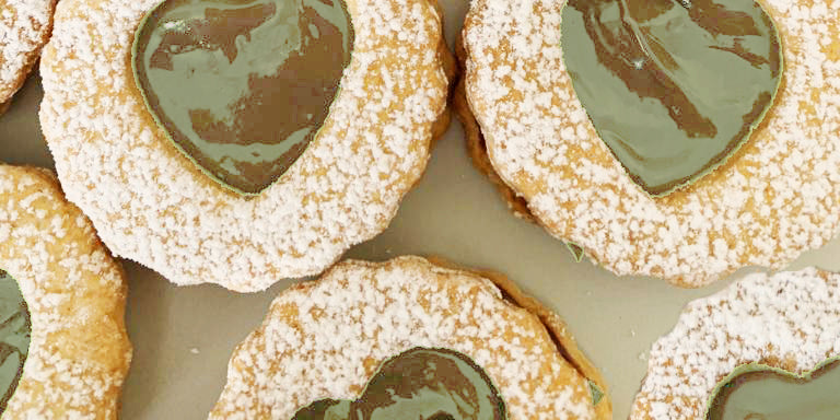 Biscotti occhi di bue con frolla alla nocciola ripieni di crema al pistacchio
